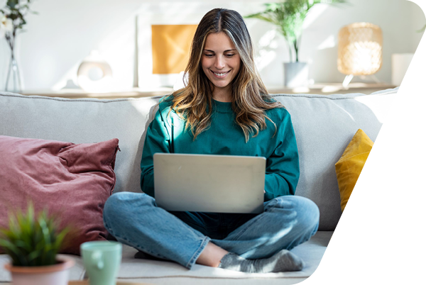 Frau auf Sofa mit Laptop auf dem Schoß